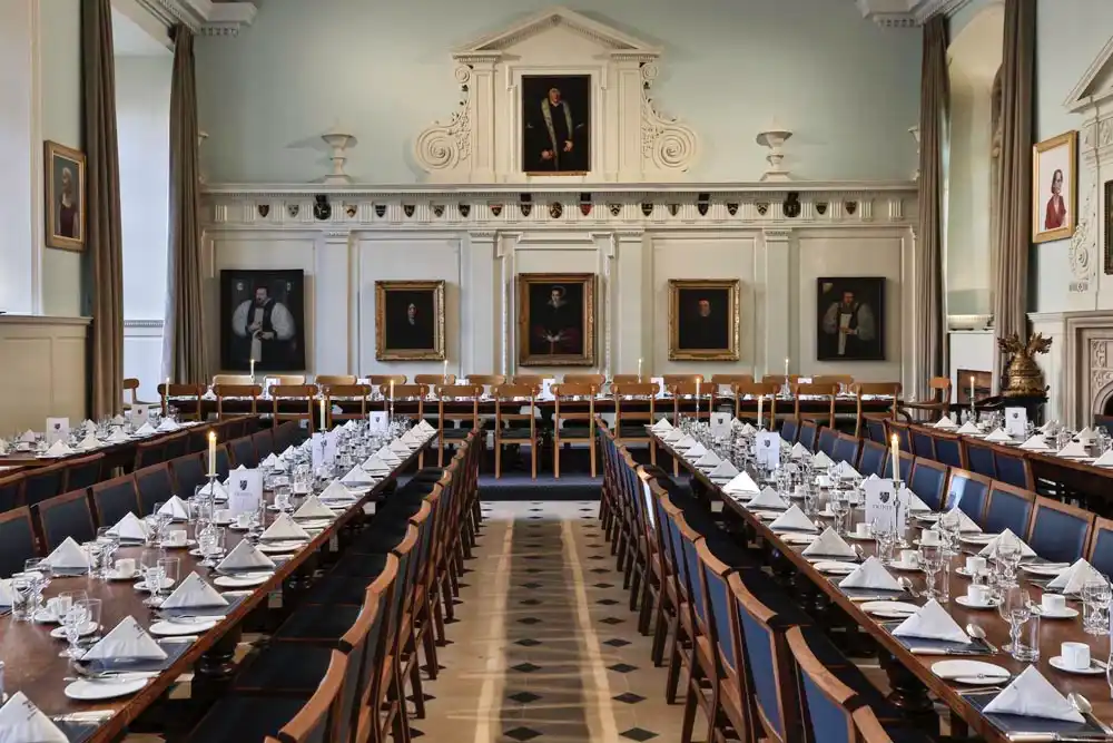 The Trinity College Oxford architect project that built in the lighting and installation to the dining room of the college. This shows the dining room with the tables set for a college dinner. It is very glamourous architecture.